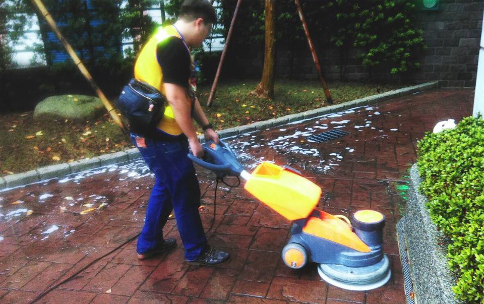 worker-cleaning-brick-floor-outside-with-big-machine