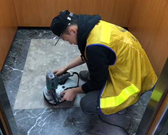 worker-cleaning-marble-elevator-floor